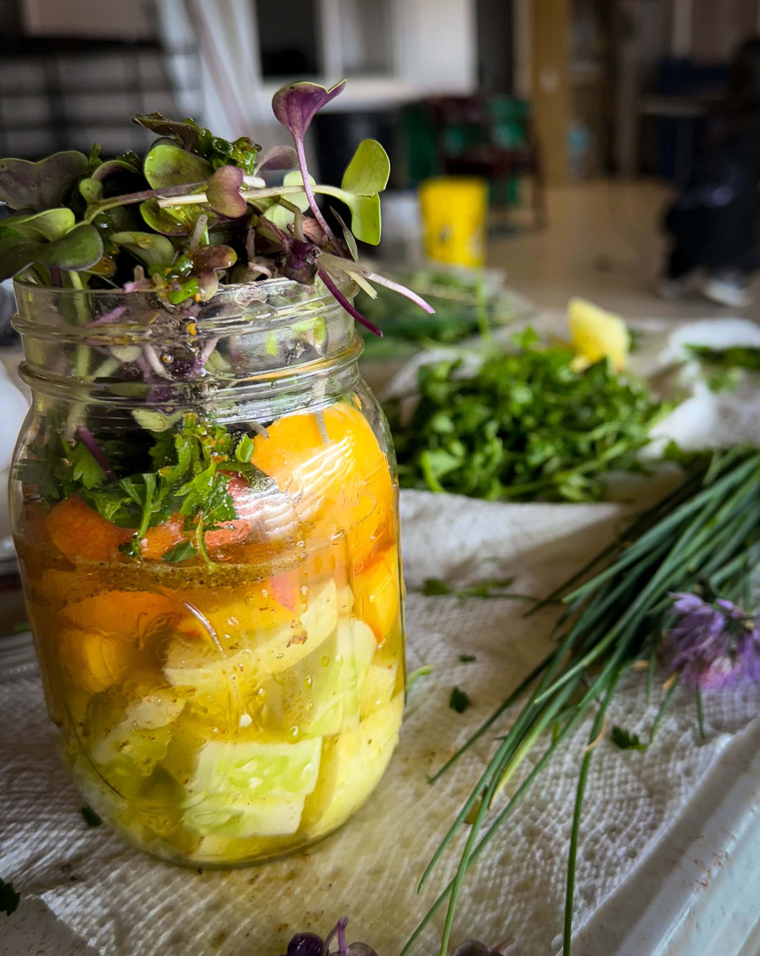 Mason jar of pickled vegetables topped with fresh microgreens