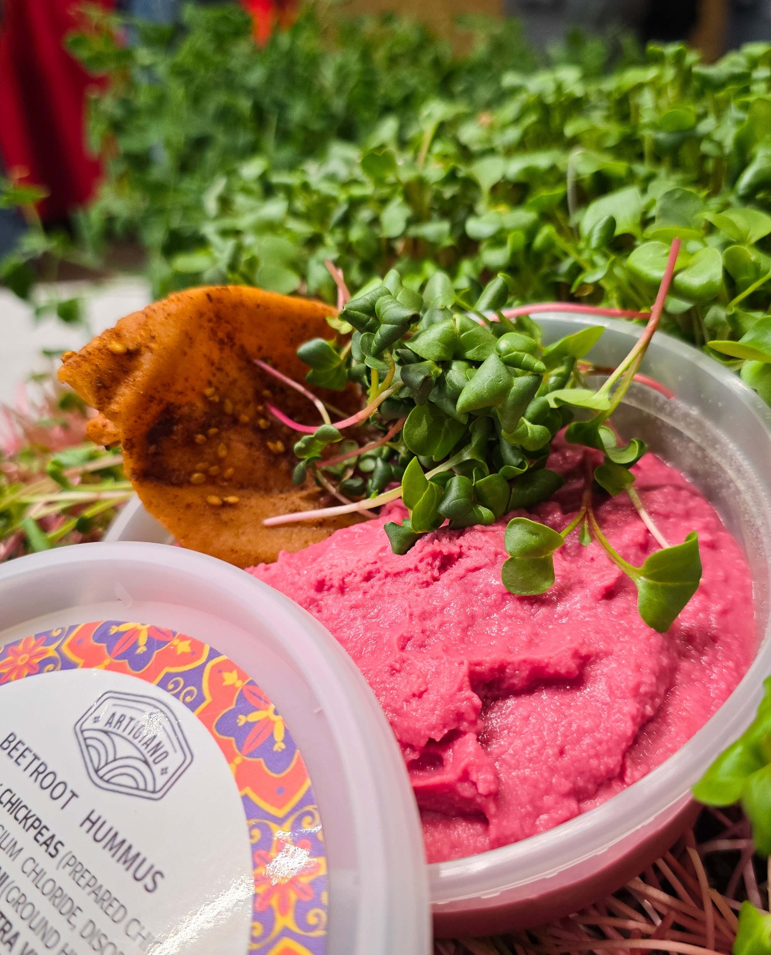 Beetroot hummus garnished with microgreens at the market